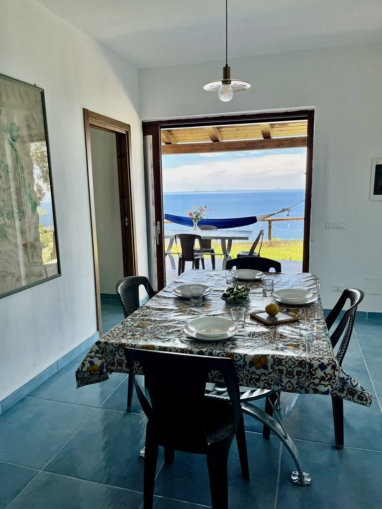 La Casa della Grotta, in pietra verde con il mare sullo sfondo